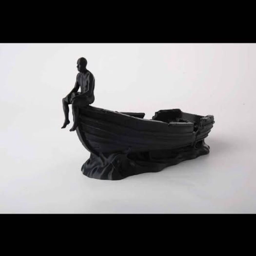 Black boat figurine with person